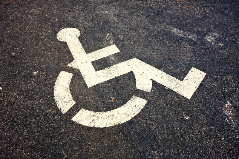 A handicap stencil on the pavement of a parking space.